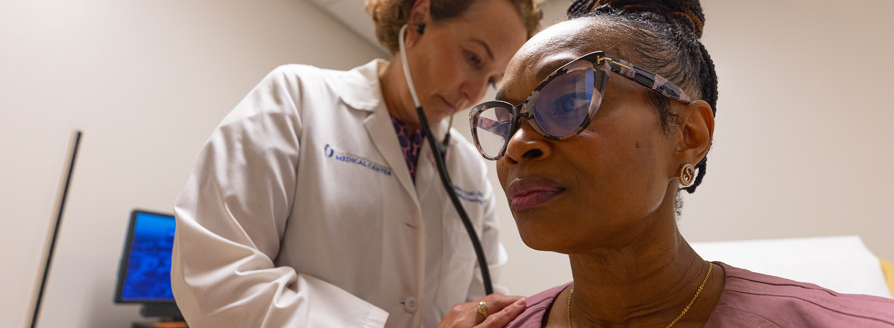 A doctor examining a breast cancer patient with a stethoscope.